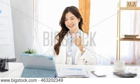 Joyful, Surprised or shocked Asian woman raised her arms all the way because she is very happy the b