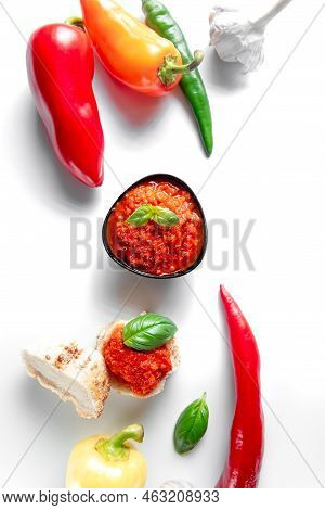 A Bowl Of Chili Sauce On A White Background. Ajika With Chili Peppers On White Background.
