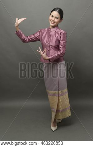 A Young Asian Woman Wearing Thai Traditional Cloth On Gray Background