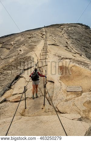 Female Hiker Begins To Climb The Cables On Half Dome In Yosemite