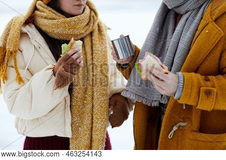 Close Up Of Young Couple Eating Lunch Outdoors In Winter During Hike