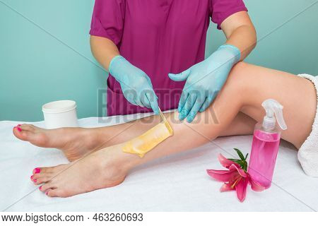 Leg Sugaring. A Beautician Makes A Sugar Paste Depilation Of A Woman's Legs In A Beauty Salon. Femal