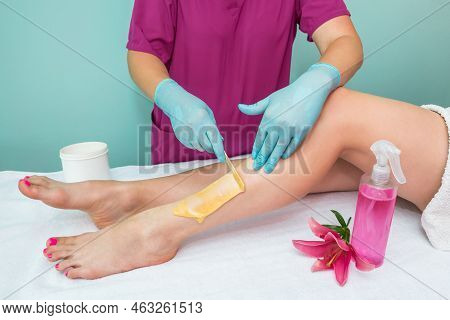Leg Sugaring. A Beautician Makes A Sugar Paste Depilation Of A Woman's Legs In A Beauty Salon. Femal