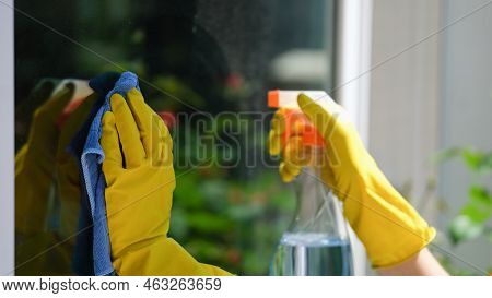 Close-up Of Female Hands Cleaning Window Outside Using Detergent Spray And Rag. House Cleaning, Hous