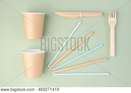Eco - Friendly Tableware On Green Background. Top View. Plastic Free Set Of Brown Paper Utensil. Str
