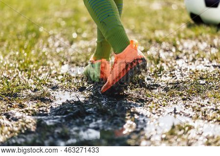Muddy Football Field. Player Walking On Muddy Soccer Pitch. Soccer Cleats Covered With Mud And Dirt