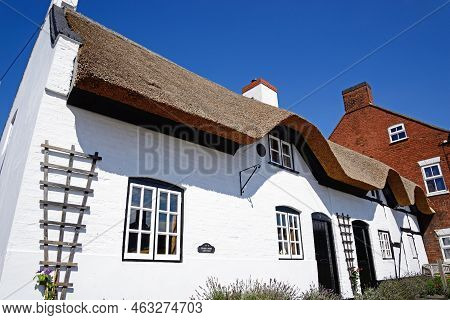 Burton-on-trent, Uk - August 7, 2020 - Pretty Traditional English Whitewashed Thatched Cottage In Th