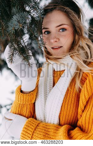 Teen Blonde In A Yellow Sweater Outside In Winter. A Teenage Girl On A Walk In Winter Clothes In A S