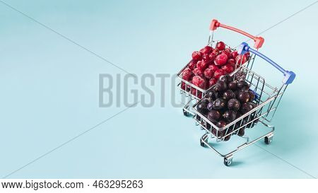 Banner Frozen Berries In Red And Black In Metal Baskets On A Light Background. The Concept Of Using 