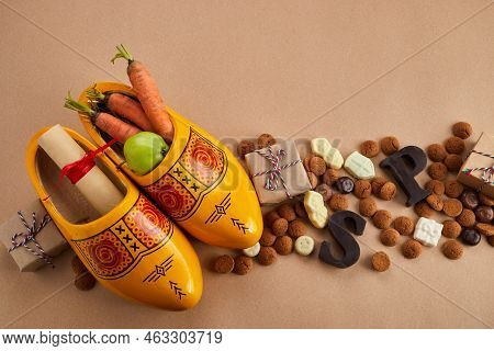 Saint Nicholas - Sinterklaas Day With Shoe, Carrot And Traditional Sweets On Caramel Background