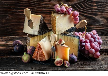 Various Kind Of Cheese, Traditional Pieces Of French, Italy And Spanish Manchego Cheese With Grapes 