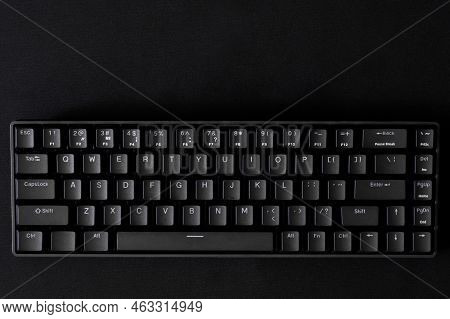 Black Mechanical Computer Keyboard On A Black Background. Small Gaming Keyboard With Reduced Interfa