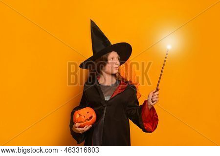 Cute Pre-teen Girl In Wizard Student Costume Holding Luminous Magic Wand Or Glowing Magic Stick With