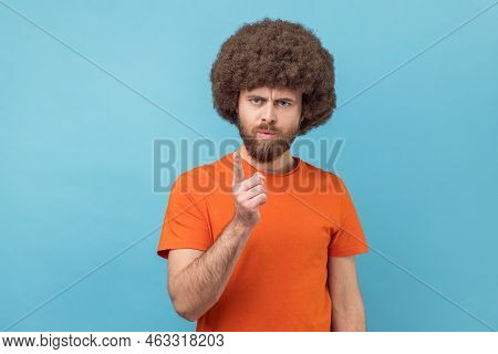 Portrait Of Serious Man With Afro Hairstyle Wearing Orange T-shirt Standing With Admonishing Gesture