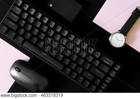 Small Compact Mechanical Computer Keyboard With 68 Keys On A Black And Pink Background Next To A Wri
