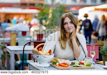 Young Beautiful Woman Drinking Coffee And Having Breakfast While Waiting For Friend. Happy Alone Wom