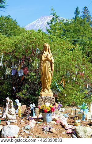 October 5, 2022 In Mt Shasta, Ca:  Spiritual Art Sculpture Besides Chaparral Plants With Tibetan Pra
