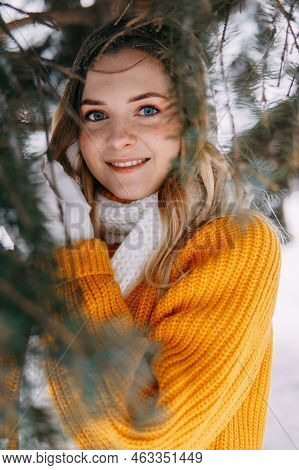 Teen Blonde In A Yellow Sweater Outside In Winter. A Teenage Girl On A Walk In Winter Clothes In A S