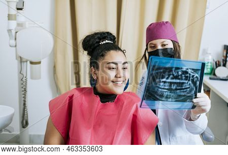 Dentist With Patient Reviewing The X-ray. Patient Looking At X-ray With Dentist, Concept Of Dentist