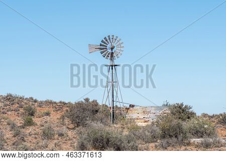 A Windmill And Rusted Corrugated Iron Dam On The Road Between Loxton And Fraserburg In The Northern 