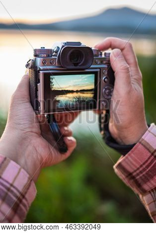 Hand Holding A Mirrorless Digital Camera Prepare For Take A Landscape Photo. Hands Taking Photo Of S