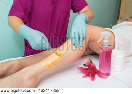 Leg Sugaring. A Beautician Makes A Sugar Paste Depilation Of A Woman's Legs In A Beauty Salon. Femal