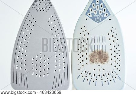 Old Iron With Damaged Soleplate And New Modern Iron On White Background, Maintenance And Care Of Mod