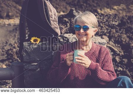 Cheerful Happy Caucasian Aged Mature Woman Enjoy A Hot Beverage Like Tea Or Coffee Resting After A T