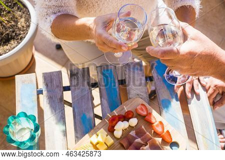Top View Old Aged Caucasian Handws From Man And Woman Senior Couple Clinking And Toasting Wine Glass