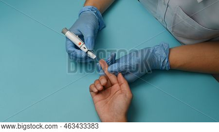Above View Of Nurse Using Lancelet On Finger Of Diabetic Patient To Checking Blood Sugar Level. Diab