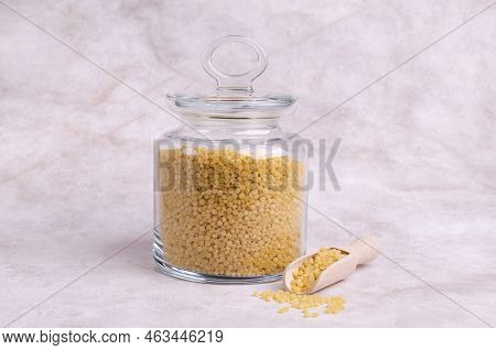 Traditional Dry Pearl Couscous In A Glass Jar On A Light Background. Selective Focus.