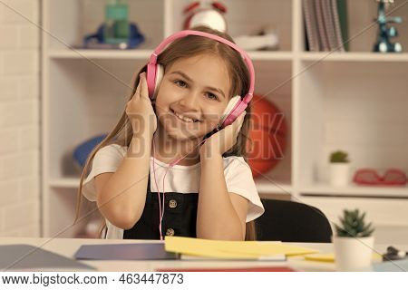 Child Smile And Listen To Music In Headphones At School Classroom