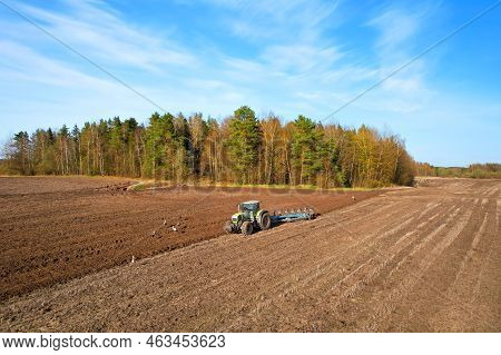 Tractor With Cultivator Plowing Field. Tractor Disk Harrow On Ploughing A Soil. Sowing Seed On Plowe
