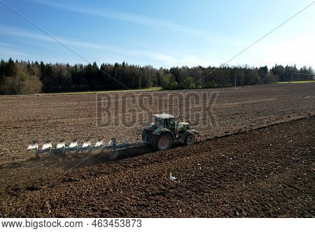 Tractor With Cultivator Plowing Field. Tractor Disk Harrow On Ploughing A Soil. Sowing Seed On Plowe