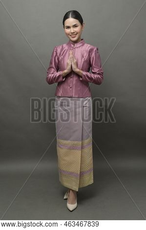A Young Asian Woman Wearing Thai Traditional Cloth On Gray Background