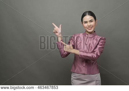 A Young Asian Woman Wearing Thai Traditional Cloth On Gray Background