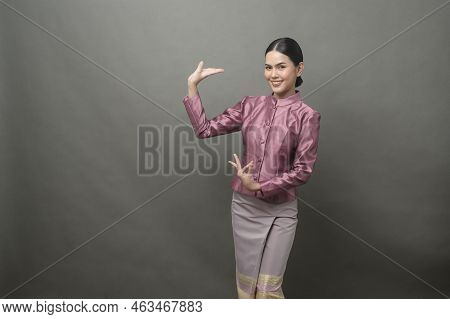 A Young Asian Woman Wearing Thai Traditional Cloth On Gray Background