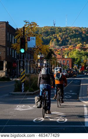 Montreal, Canada - 11 October 2022: People Riding Bikes On Rachel Street With Mount Royal In Backgro