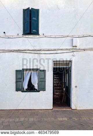 Facade Of A Traditional White House, In A Mediterranean Fishing Village, With The Door And Windows O