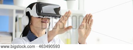 Young Female Doctor In Virtual Reality Headset Works On Computer In Hospital Office. Offi Vr Headset