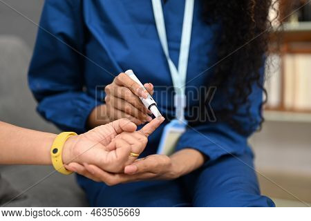 Cropped Shot Of Nurse Using Lancelet On Finger Of Diabetic Patient To Checking Blood Sugar Level. Di