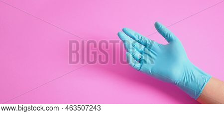 Hand Is Wear Blue Latex Glove Or Doctor Glove On Pink Background.