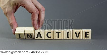 Active Or Inactive Symbol. Businessman Turns Wooden Cubes And Changes The Word Inactive To Active. B