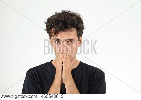 Frustrated And Scary Young Man In Black T-shirt Closing His Nose By Hands