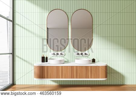 Green Bathroom Interior With Double Sink And Deck With Accessories, Hardwood Floor. Panoramic Window