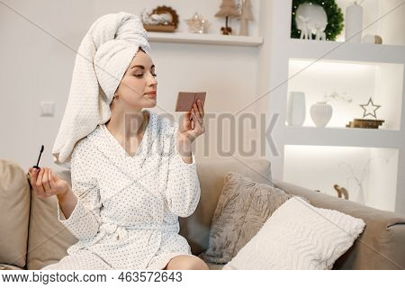 Woman Wearing Dressing Gown And Has A Towel On Her Hair Doing A Make Up