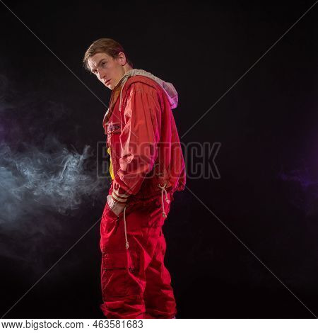 A Young Muscular Man In A Bright Outfit Poses In A Pretentious Pose, Style And Grotesque. Attractive