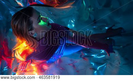 Glamorous Portrait Of A Young Beautiful Blonde In A Stylish Scarlet Short Dress, Sitting On The Floo