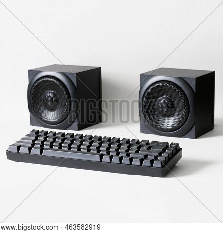 Black Mechanical Computer Keyboard And Two Square Audio Speakers On A White Background. Concept Of A