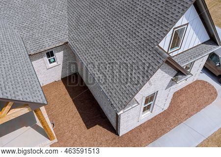 Roof Of Newly Built House Is Being Covered With Asphalt Shingles During Construction While House Is 